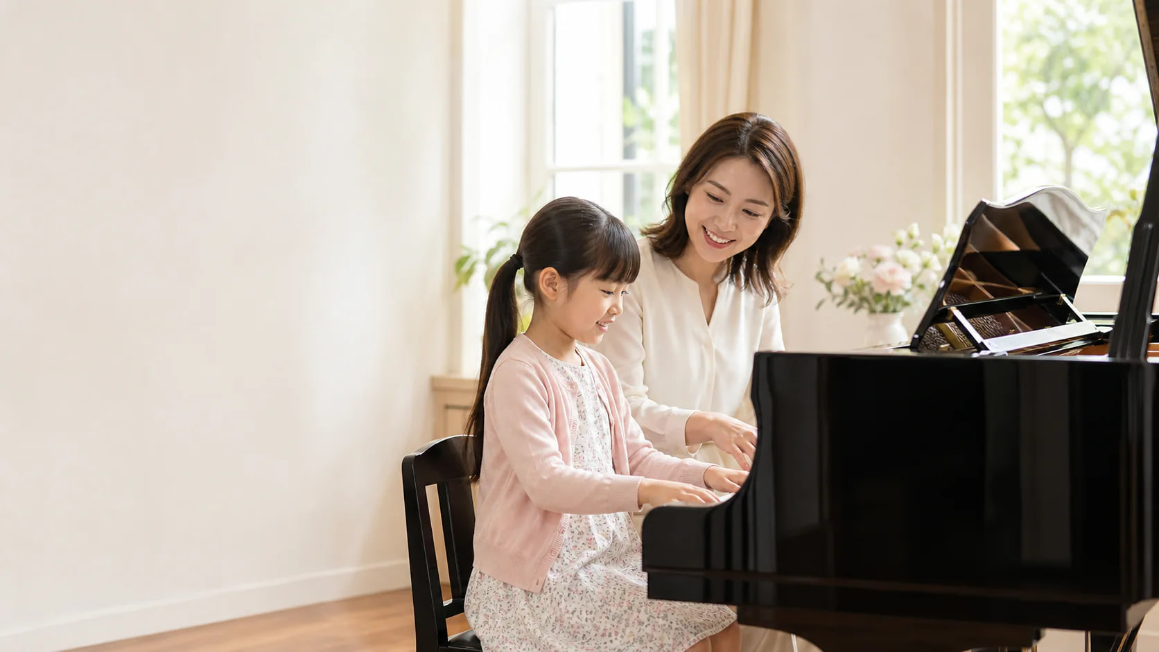 先生と生徒がピアノのレッスンをしている様子